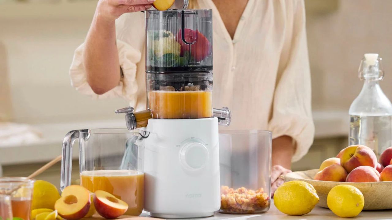 Nama J2 Juicer on a countertop with soft fruit scattered around it