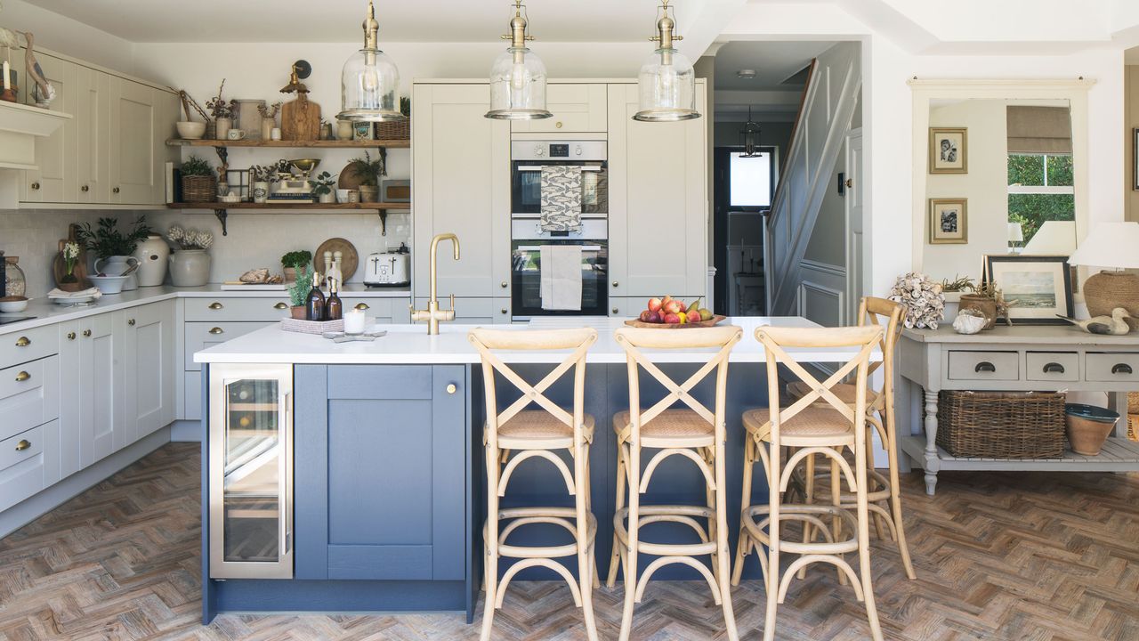 Blue kitchen island with breakfast bar in open-plan kitchen with cream coloured units