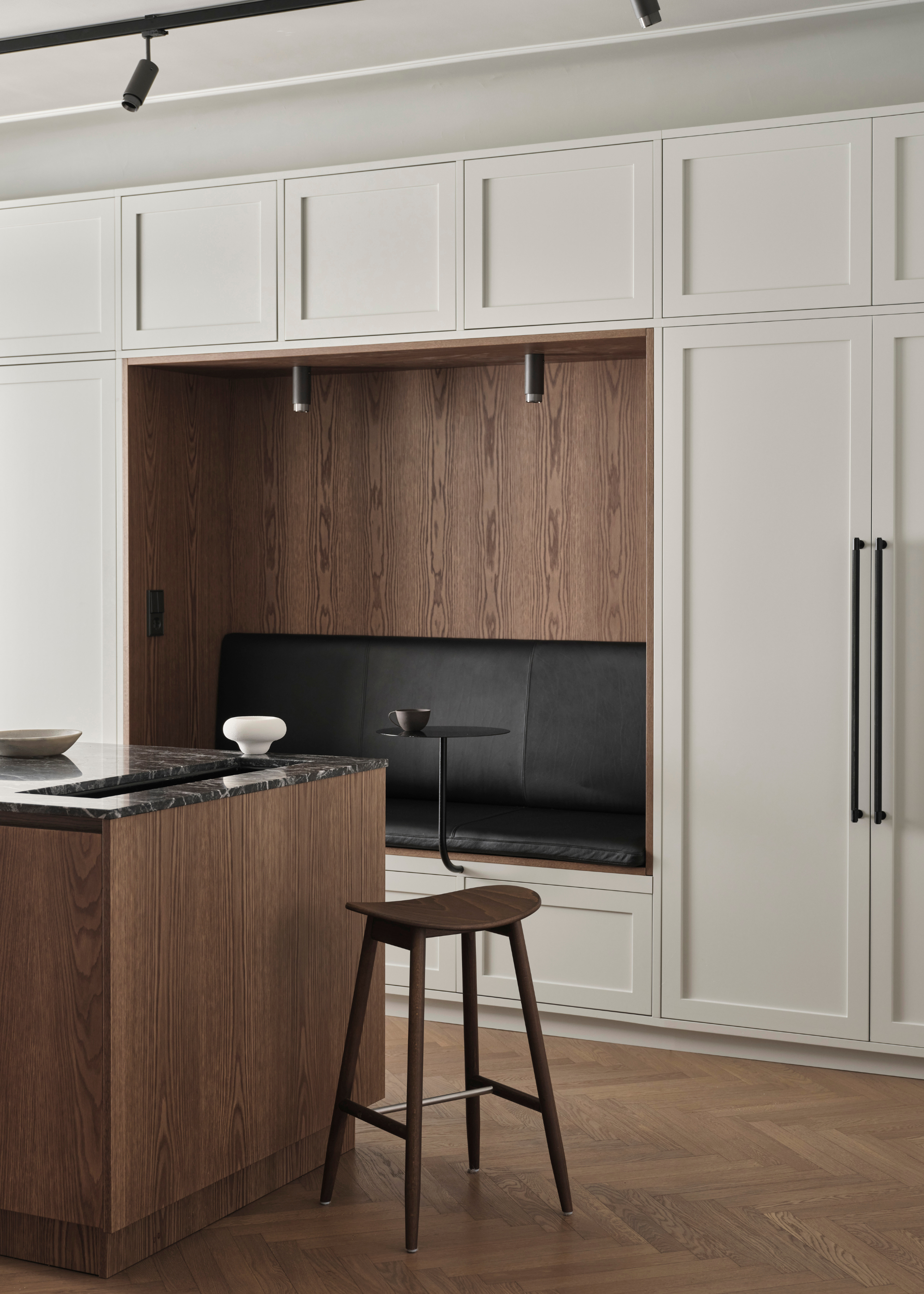 a neutral kitchen with dark wood and a built in seating area