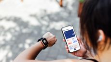 Woman using fitness tracker smart watch and app