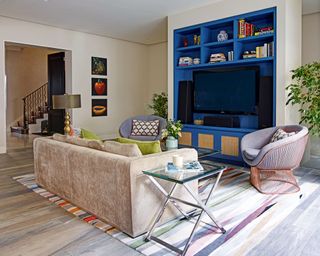 Living room with blue painted TV alcove and storage