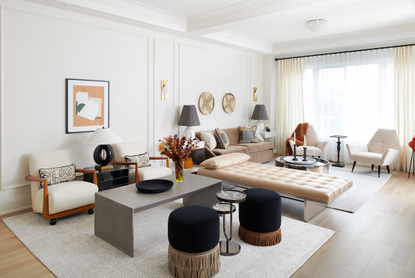 A living room where two seating areas are separated by a daybed