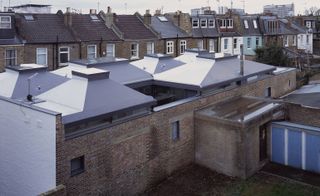 Aerial view of the grey roof of a residential home featuring a playful harlequin pattern from the two tones of single-ply roofing membrane used