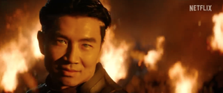 a blue-eyed Asian man with flames in the background