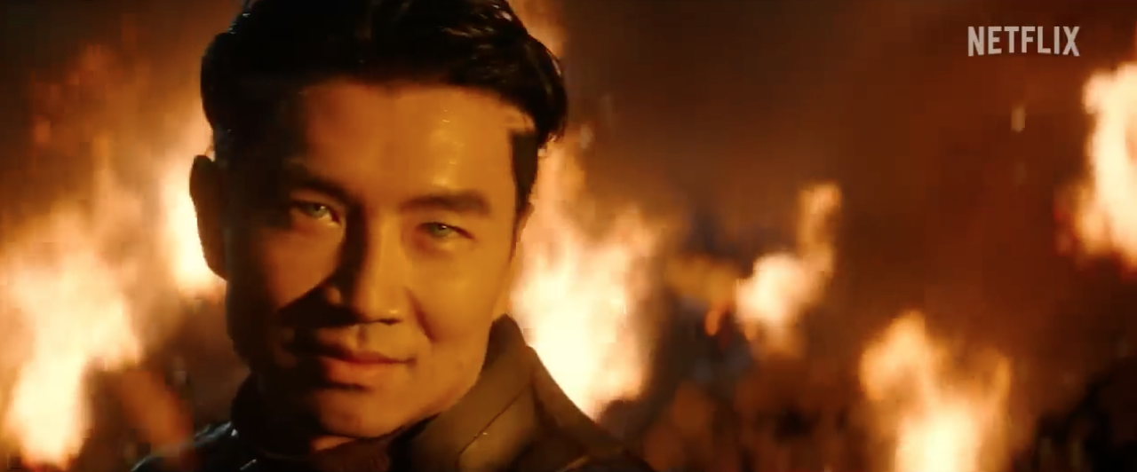 a blue-eyed Asian man with flames in the background