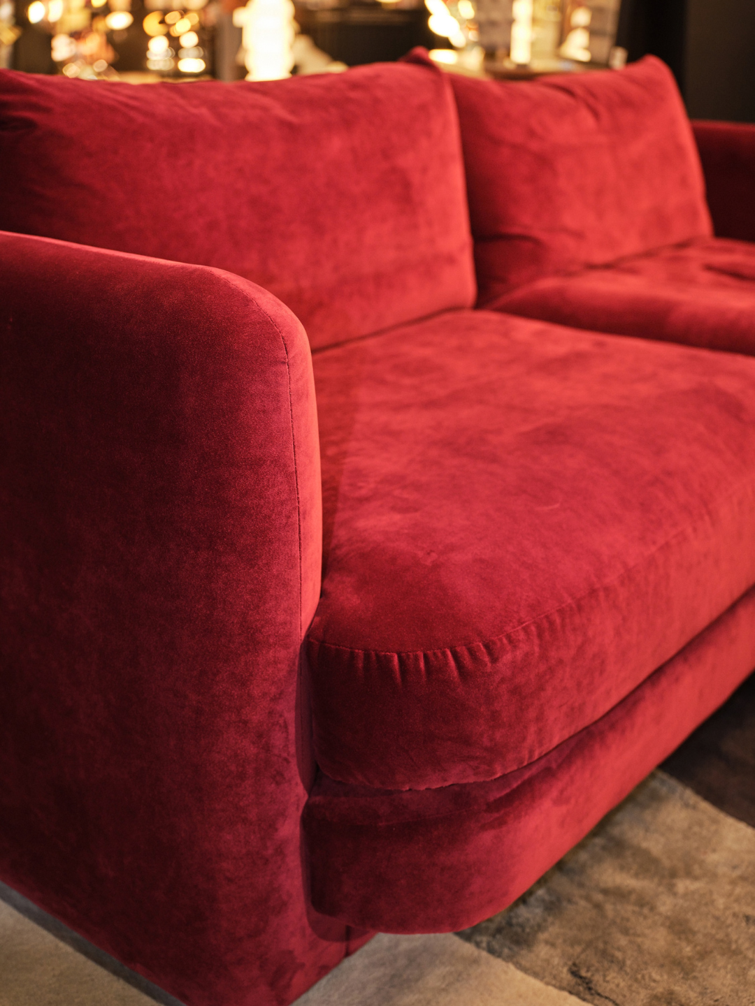 Close-up of the Heal&rsquo;s Rafi sofa showing its curved arm, deep seat cushion and neat seam detailing in velvet.