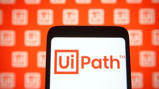 UiPath logo appearing on a smartphone set against an orange background with smaller UiPath logos in white sequenced around it