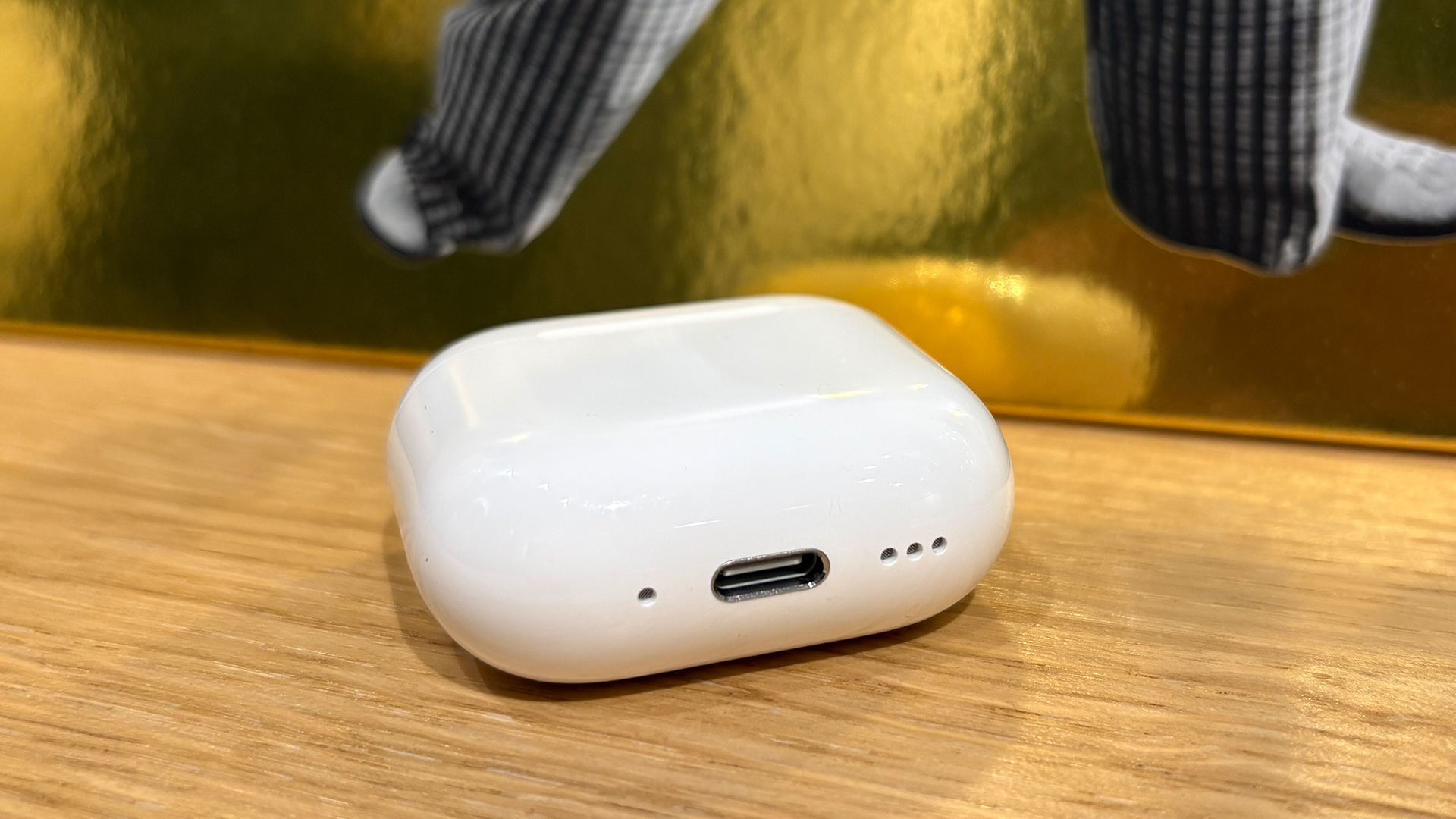 Apple AirPods 5 with Wireless Charging Case in-ear headphones case on wooden shelf