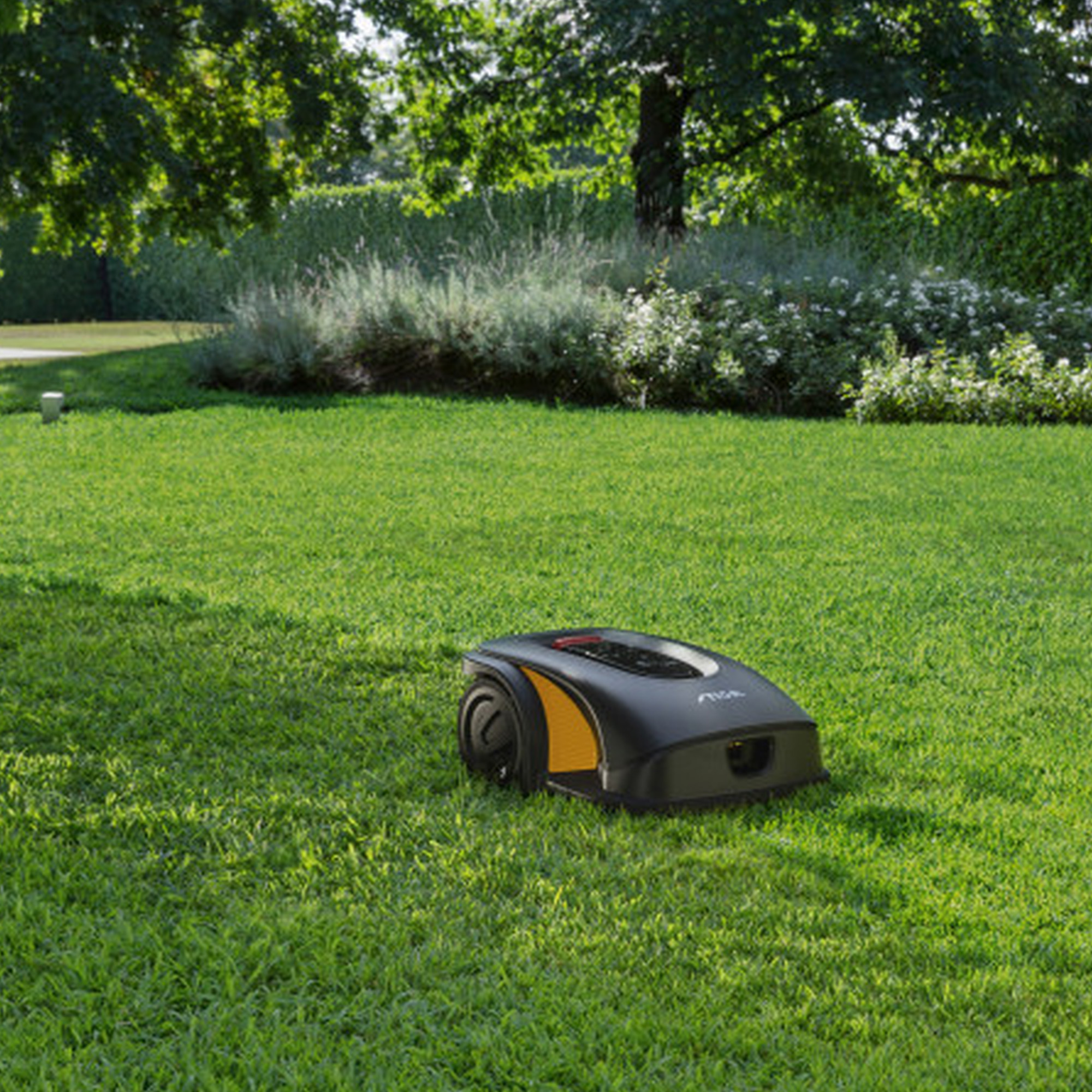 a large lawn in a garden with a Stiga robot mower
