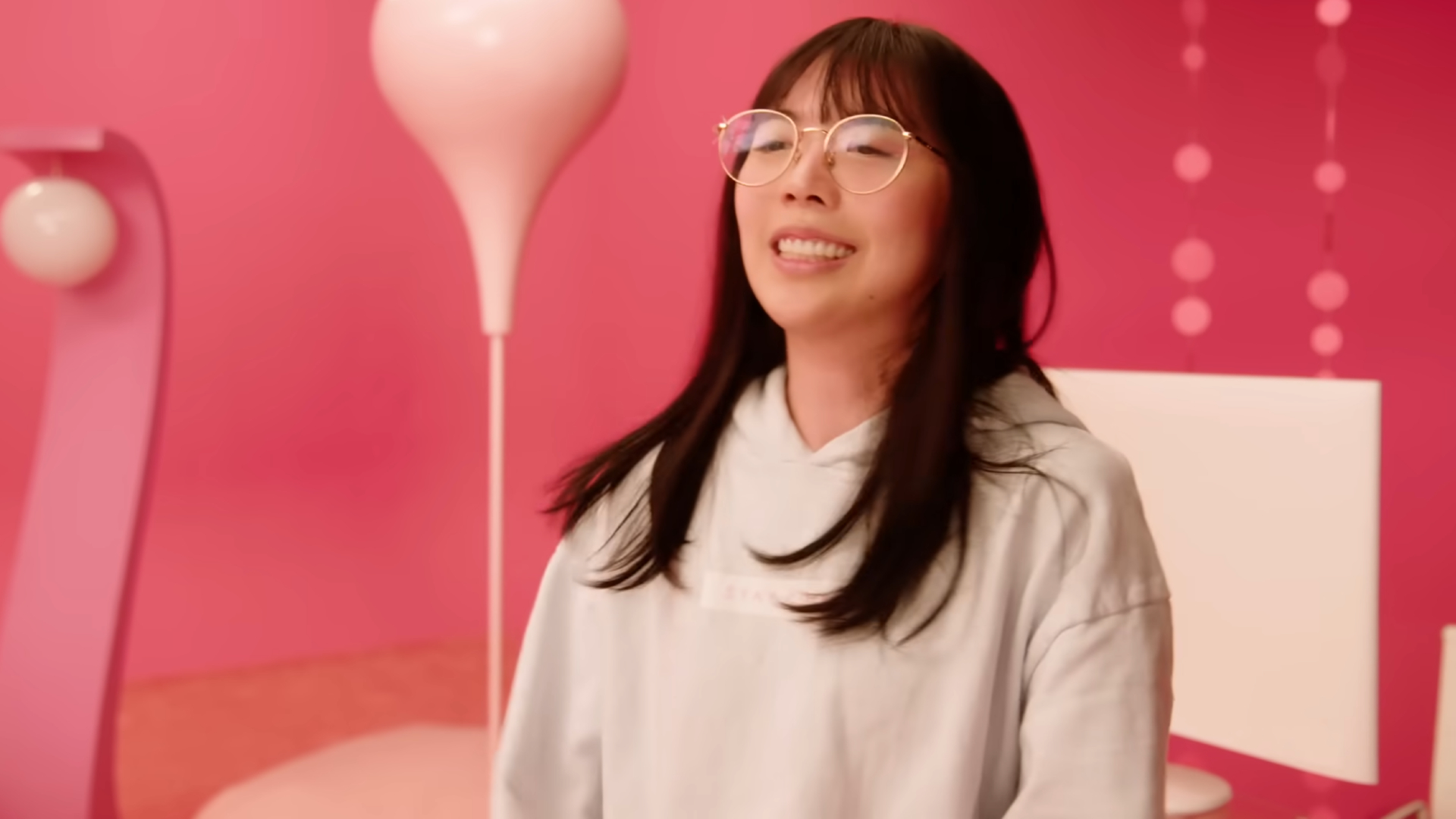 LilyPichu in a pinkish-red room in her 