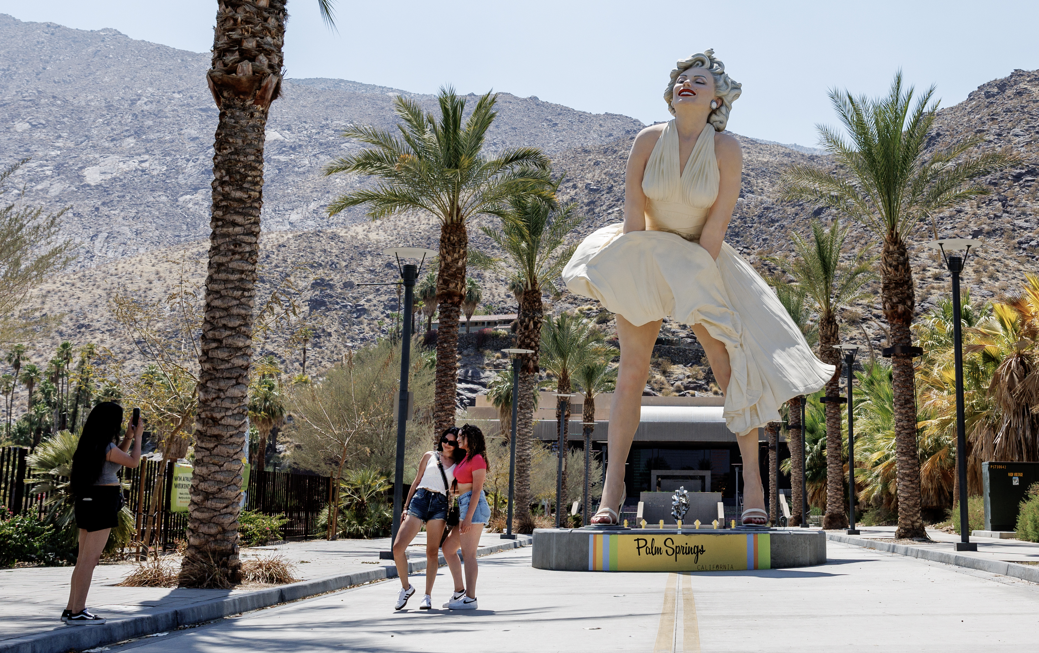 Tourists take photos in front of the Marilyn Monroe statue in Palm Springs, California.