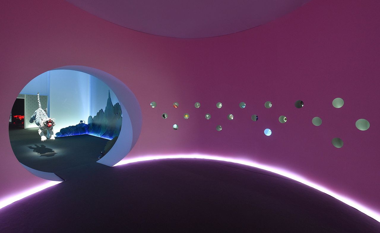 Purple walls with circular entrance, holes through wall and 3D tiger sculpture