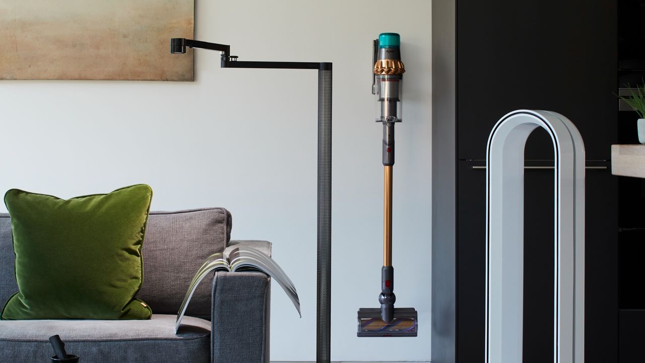 Dyson cordless vacuum cleaner hanging on wall bracket in living room