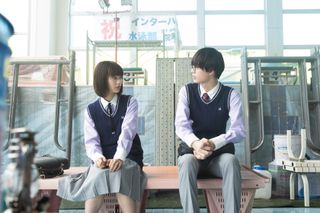 Two Japanese students sit next to each other in a workshop, in 'Chastity High.'