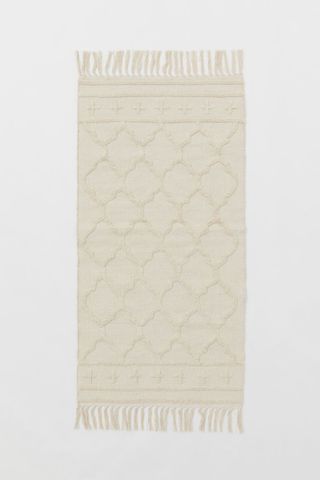 beige rectangular tasseled rug