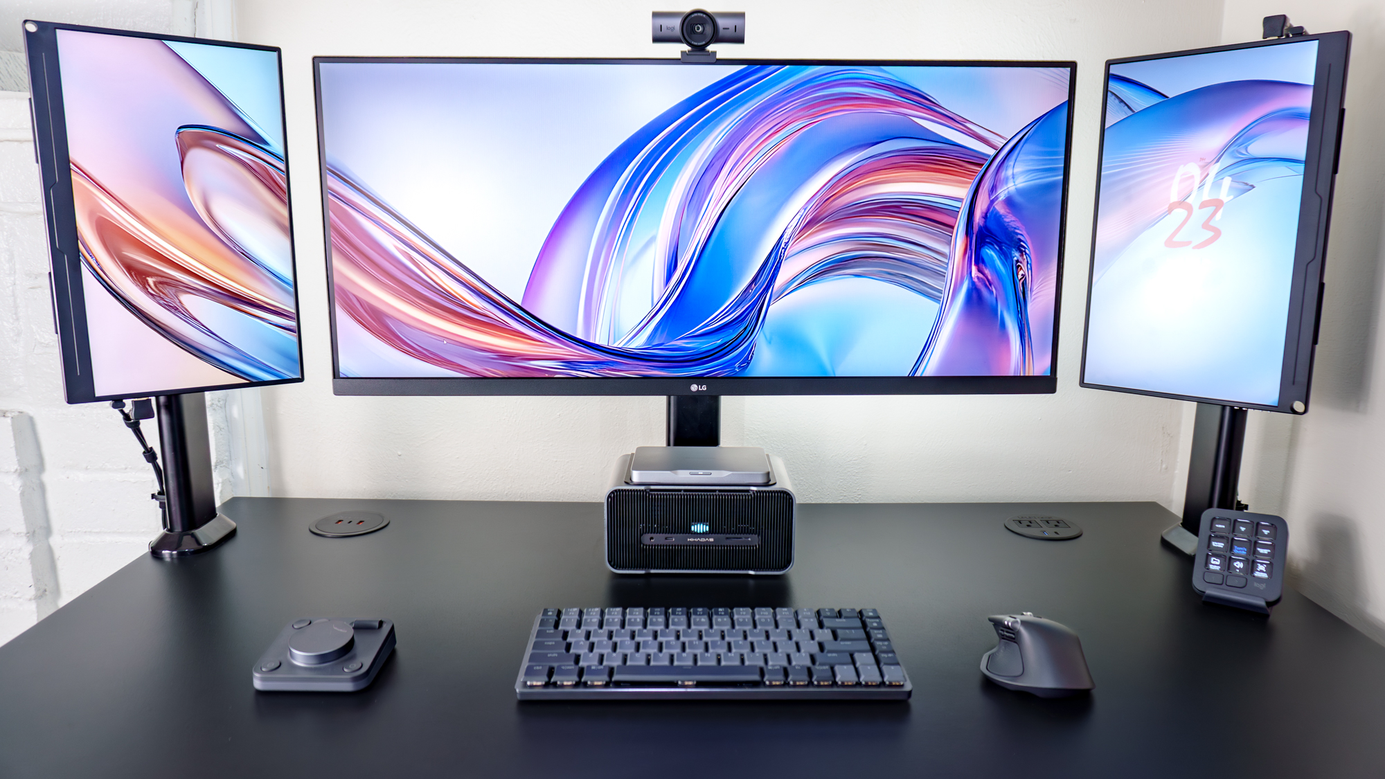 A triple monitor setup powered by the Khadas Mind 2S with the Mind Graphics 2 magnetically attached underneath it