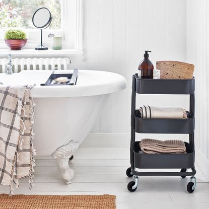 bathroom with white wall, wooden floor and bathtub