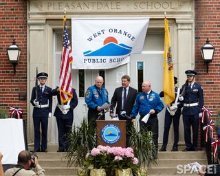 Mark and Scott Kelly behind podium up steps in front of a school