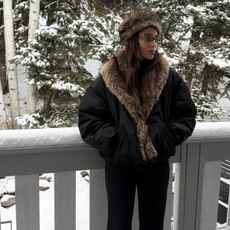 Bettina Looney wearing a black fur-trimmed jacket in the snow.