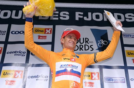 Alex Kristoff in the leader's jersey waves from the podium