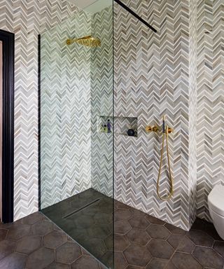 Different bathroom tile ideas behind a frameless shower screen with marble and mosaic effect tiles