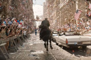 Indiana Jones rides on horseback through New York City during the ticker tape parade thrown for the Apollo 11 astronauts in a scene from "Indiana Jones and the Dial of Destiny," now in theaters.