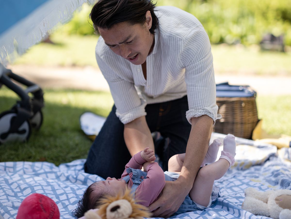 Leo Tanaka (Tim Kano) struggles with baby Abi in Neighbours