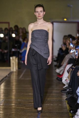 Paloma Wool model weairng a strapless top with a black skirt-over-pants trend at the fall/winter 2024 show.
