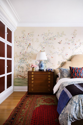 Bedroom with floral wallpaper and large patterned rug