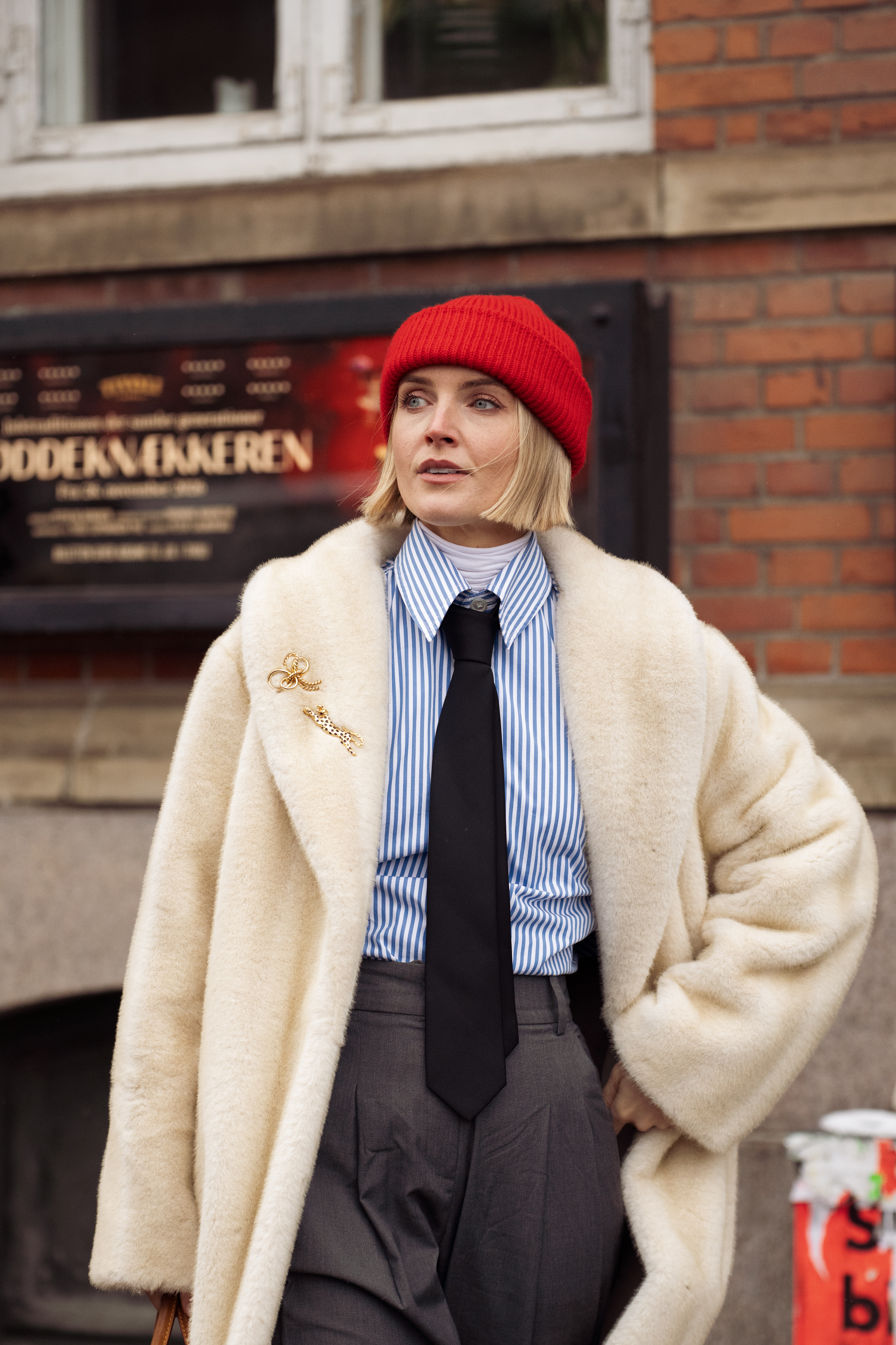 Polly Newman wears a cream faux fur coat and brooches