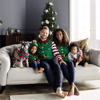 Family wearing Aldi Elf Christmas jumpers in living room