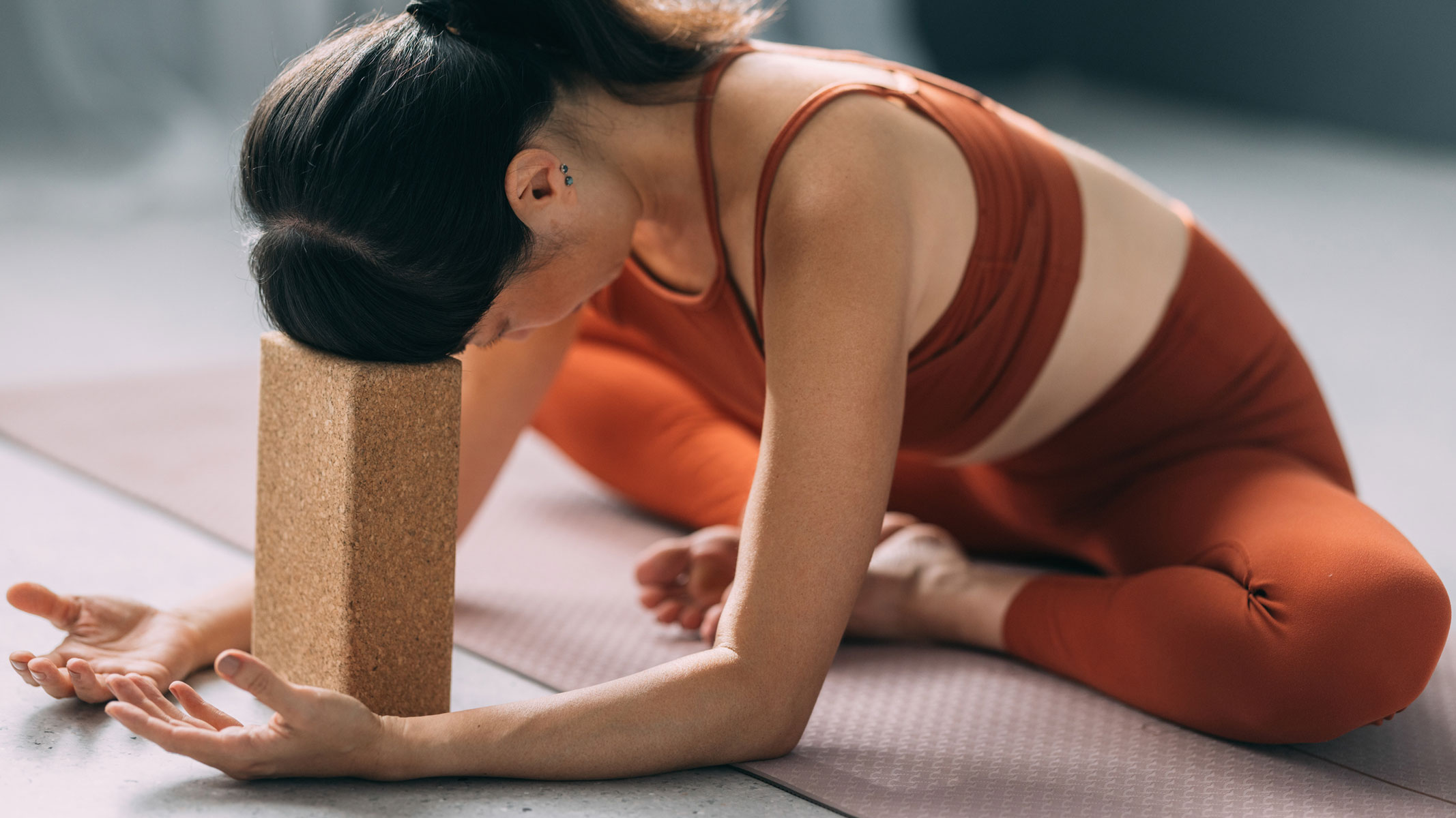 A picture of a young woman exercising using a yoga block