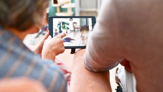 An interior designer working with a client, showing her designs on an iPad