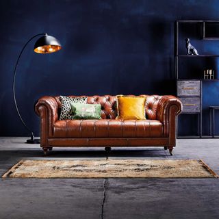 Brown chesterfield sofa in a blue living room