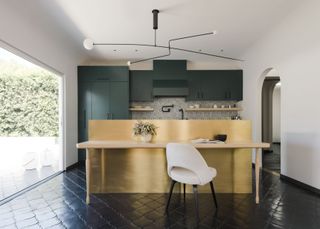 A kitchen with petrol green cabinets