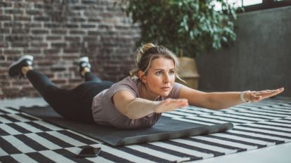 woman on mat in superman hold