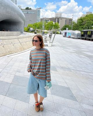 Erika Boldrin in a brown striped T-shirt and brown Miu Miu x New Balance sneakers.