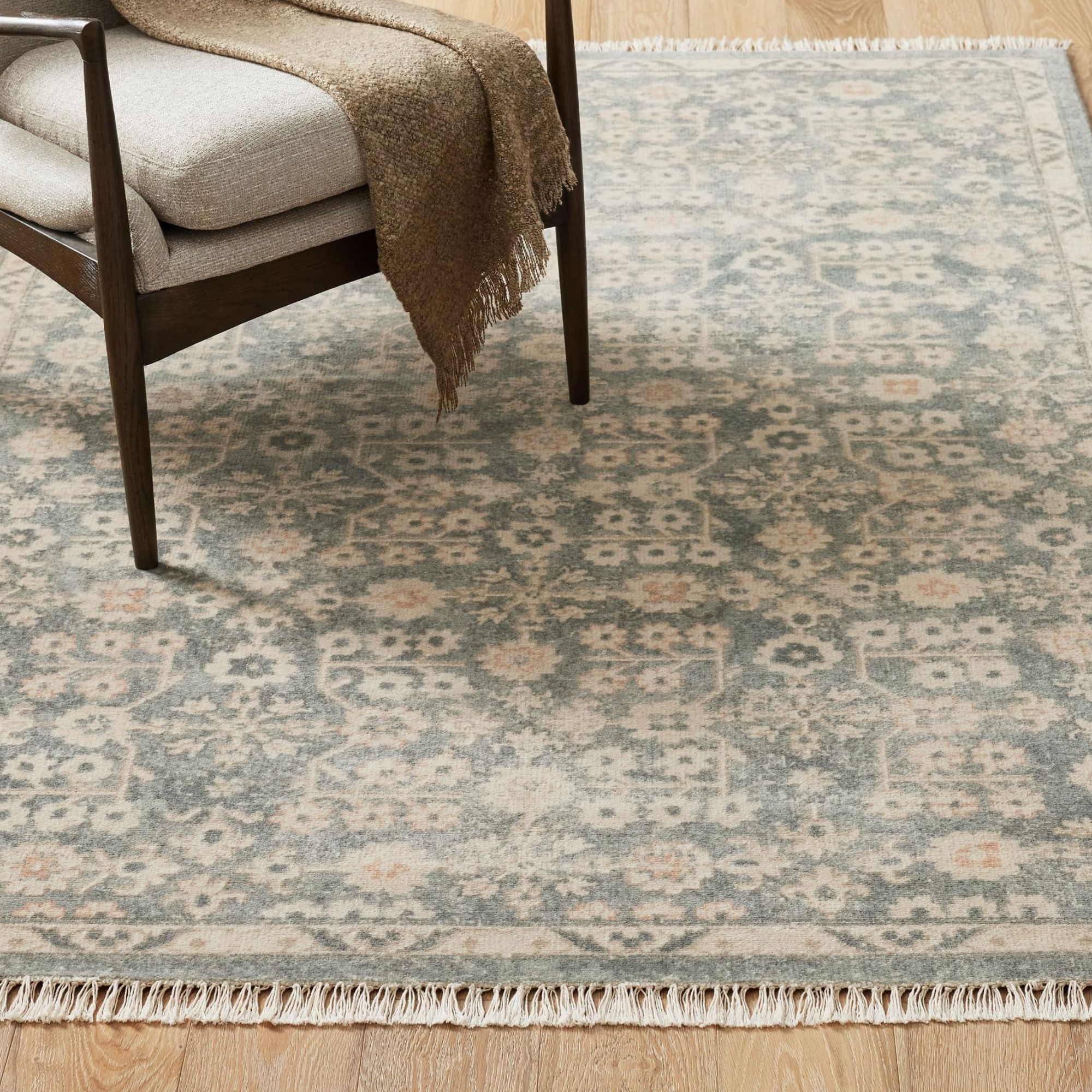 Pale blue-green patterned rug with hints of cream and orange