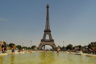 waders bathe in front of eiffel tower during a heat wave in paris