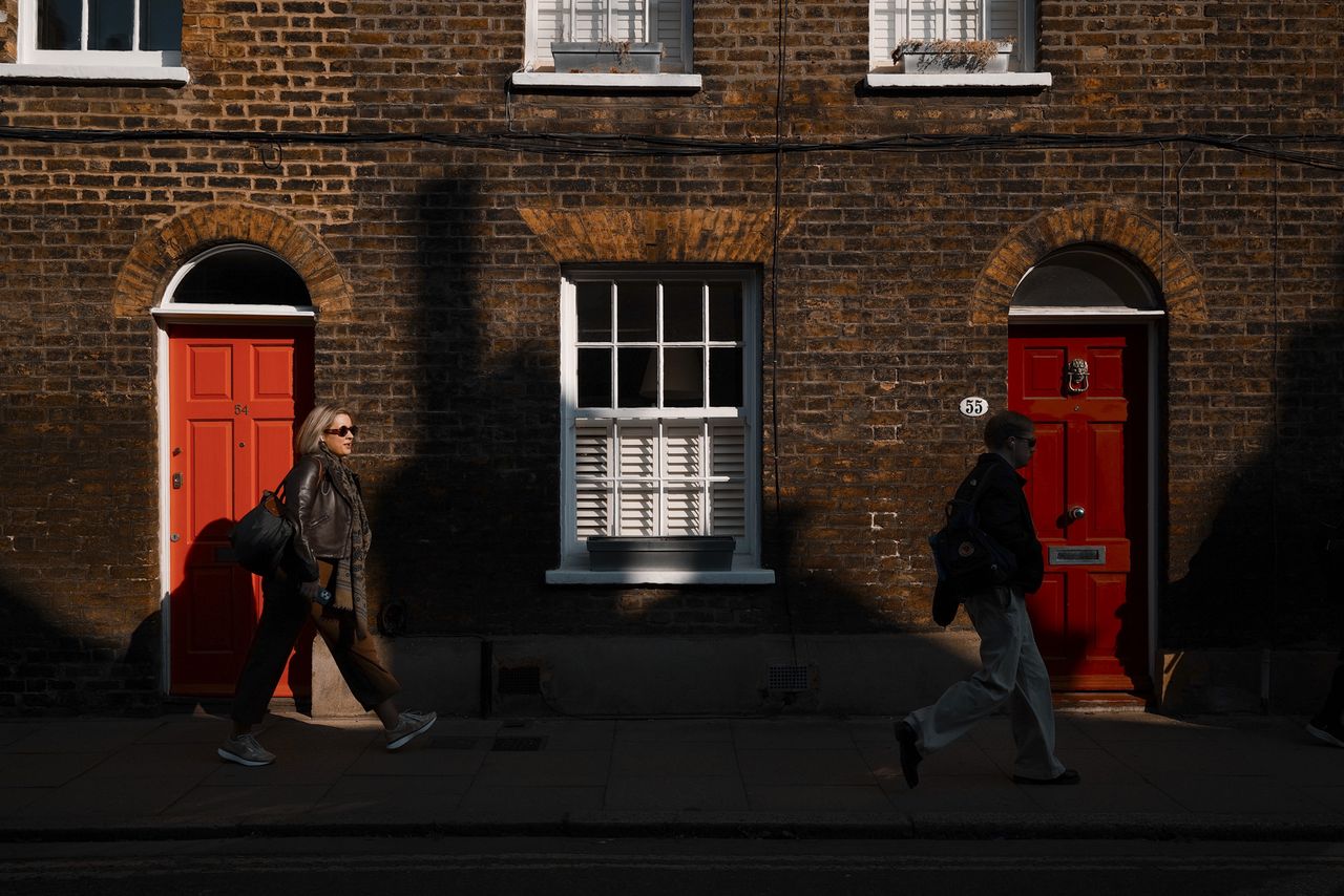 London street photo of people walking down old street in bright sunlight with strong shadows cast on the wall, taken with the Sigma BF camera and Sigma 35mm F2 DG lens