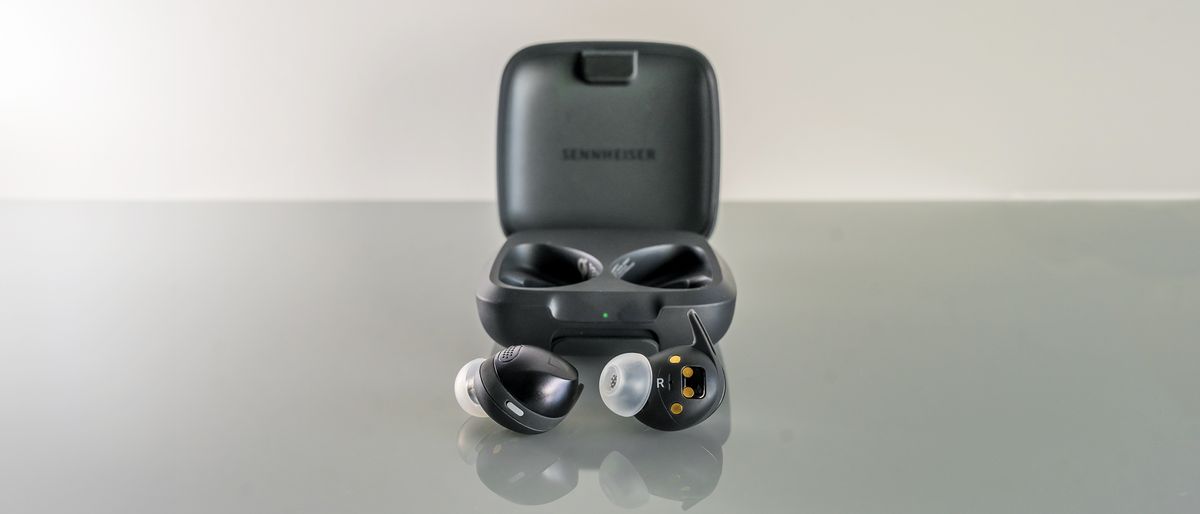 Sennheiser Momentum Sport earbuds loose in front of open case.