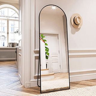 An arched mirror leaning against a wall