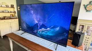 TCL P755K 65-inch 4K TV on wooden table showing starry night landscape on screen