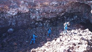 Selene IV crewmembers explore a lava cave near the HI-SEAS habitat for habitability and astrobiology research.