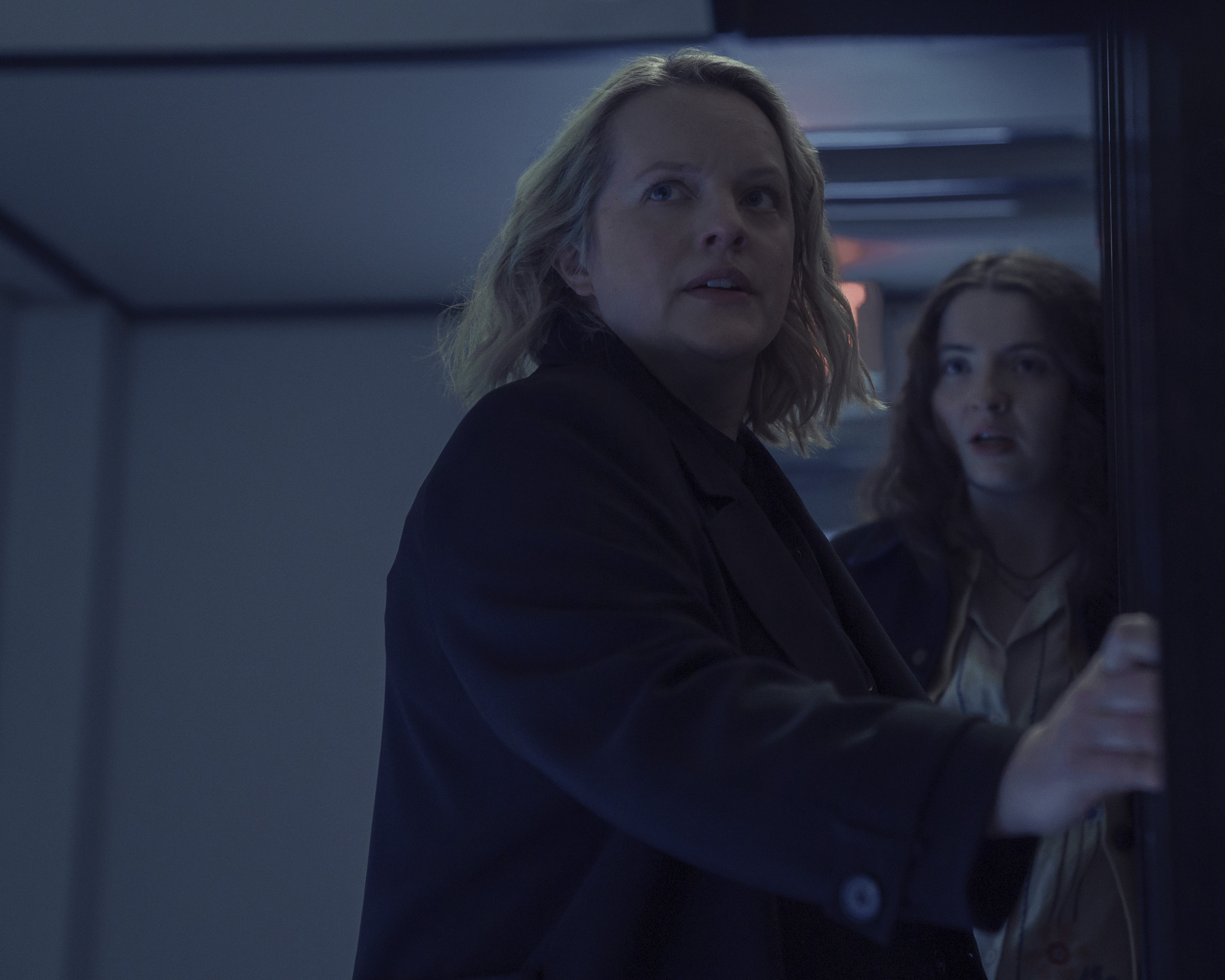 elisabeth moss as june escaping from a hospital with lucy halliday as lucy in the testaments episode 3