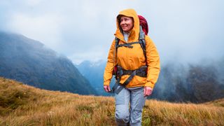 Woman walking in full weatherproof clothing on hike