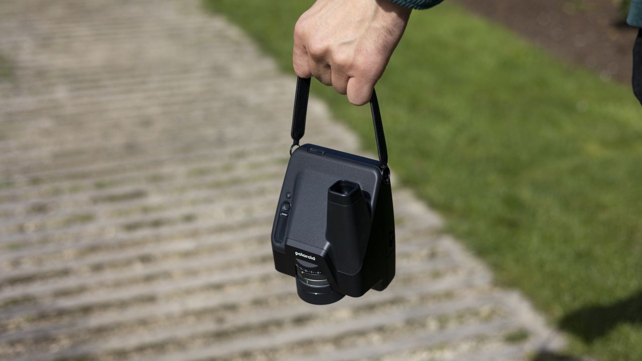 A Polaroid I-2 being carried by the handle