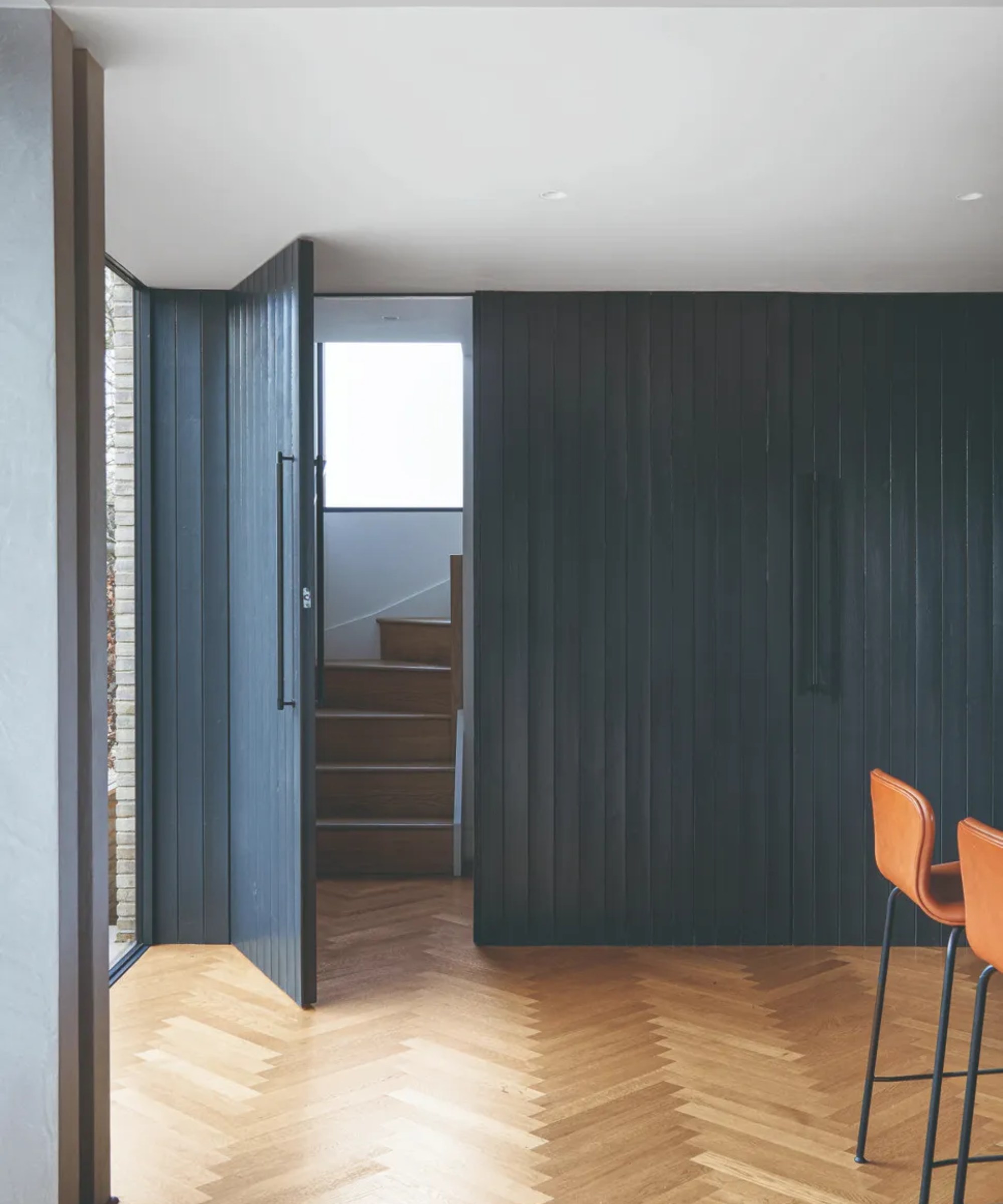 Staircase hidden behind a blue panelled door with wooden flooring beneath