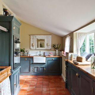 kitchen with dark grey and topped with wooden worksurfaces
