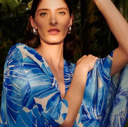A woman wearing a blue and white patterned, floaty dress from Monsoon. 